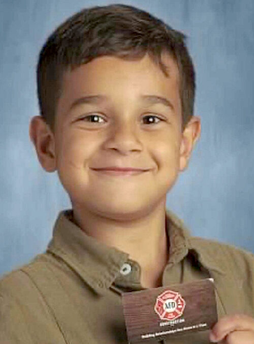 Eight year old poses with business card for school picture, becomes “VP” for the day