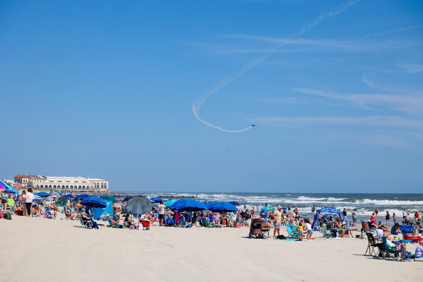 Crowds watch an aerobatic plane over the Ocean City beach