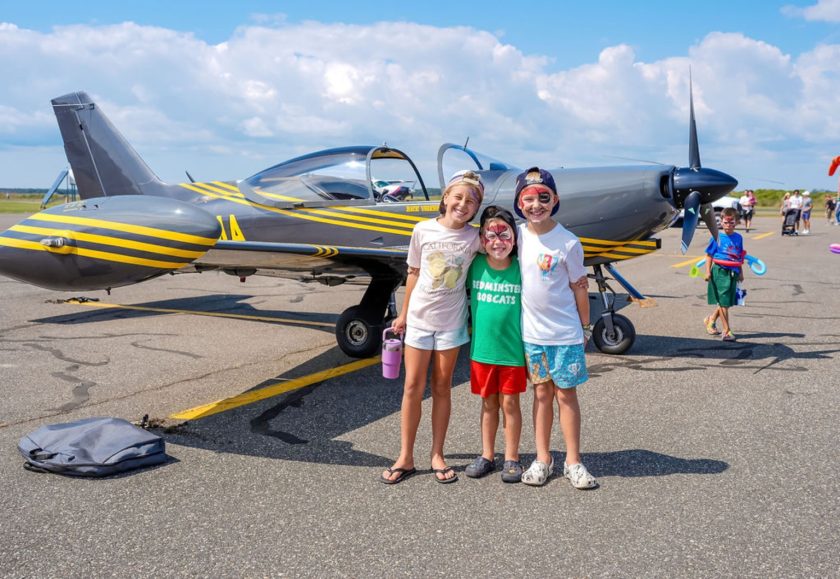 Children pose beside an aircraft at the Ocean City Airport Festival