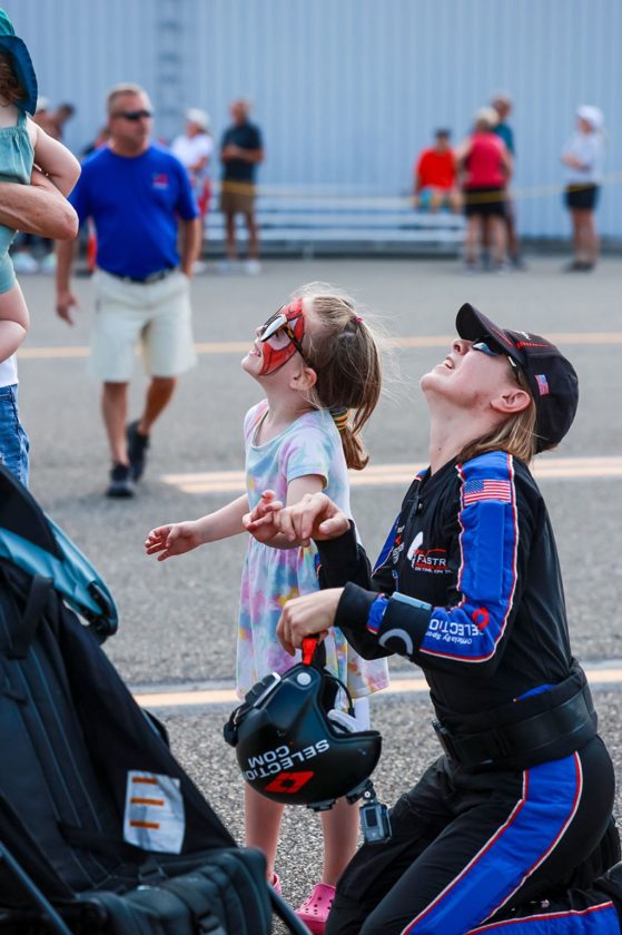 A child watches the sky with a Team Fastrax member at the airport festival