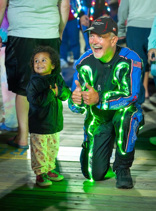A Team Fastrax member greets a child after the nighttime parachute show